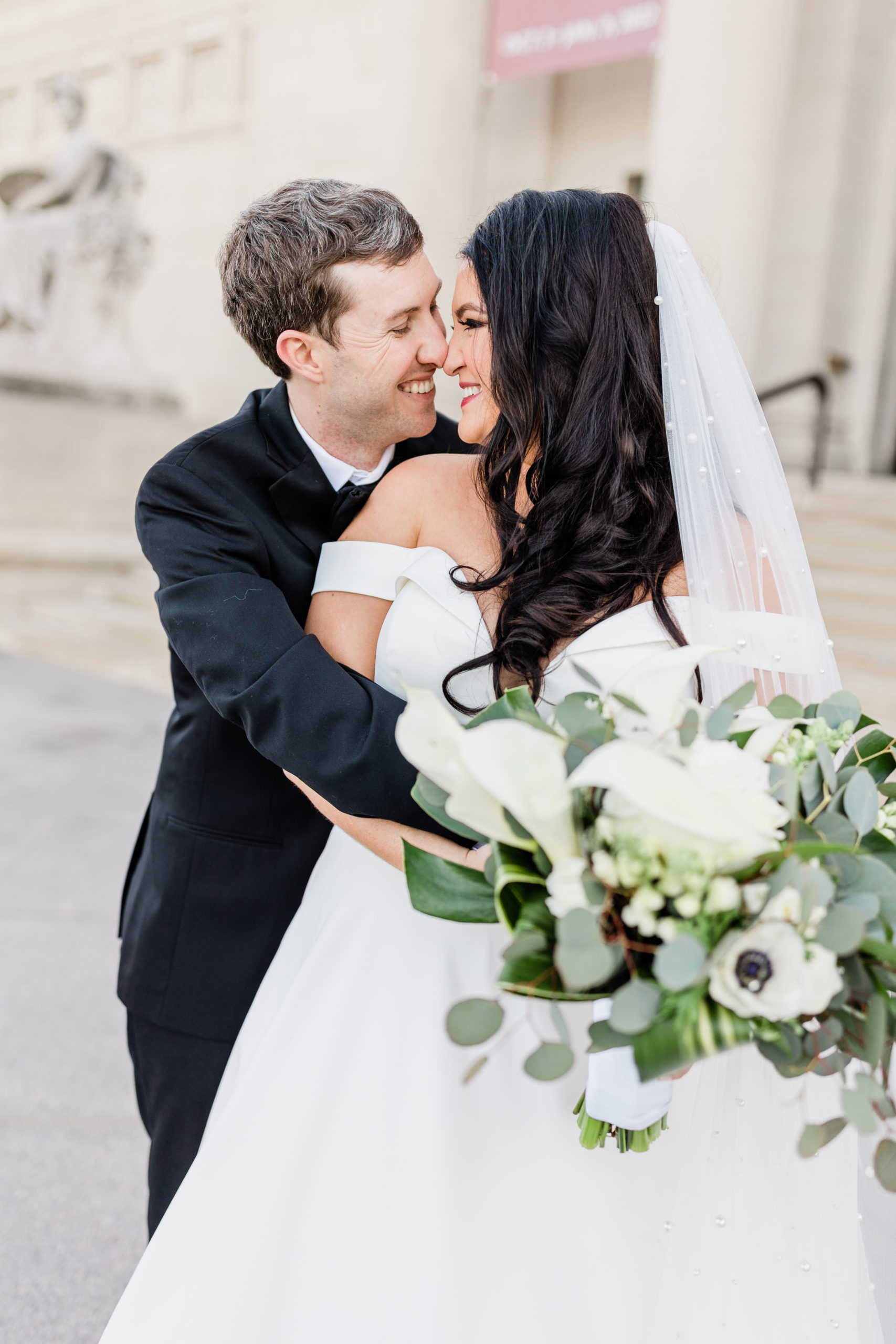 bride and groom hugging at st. louis art museum after wedding