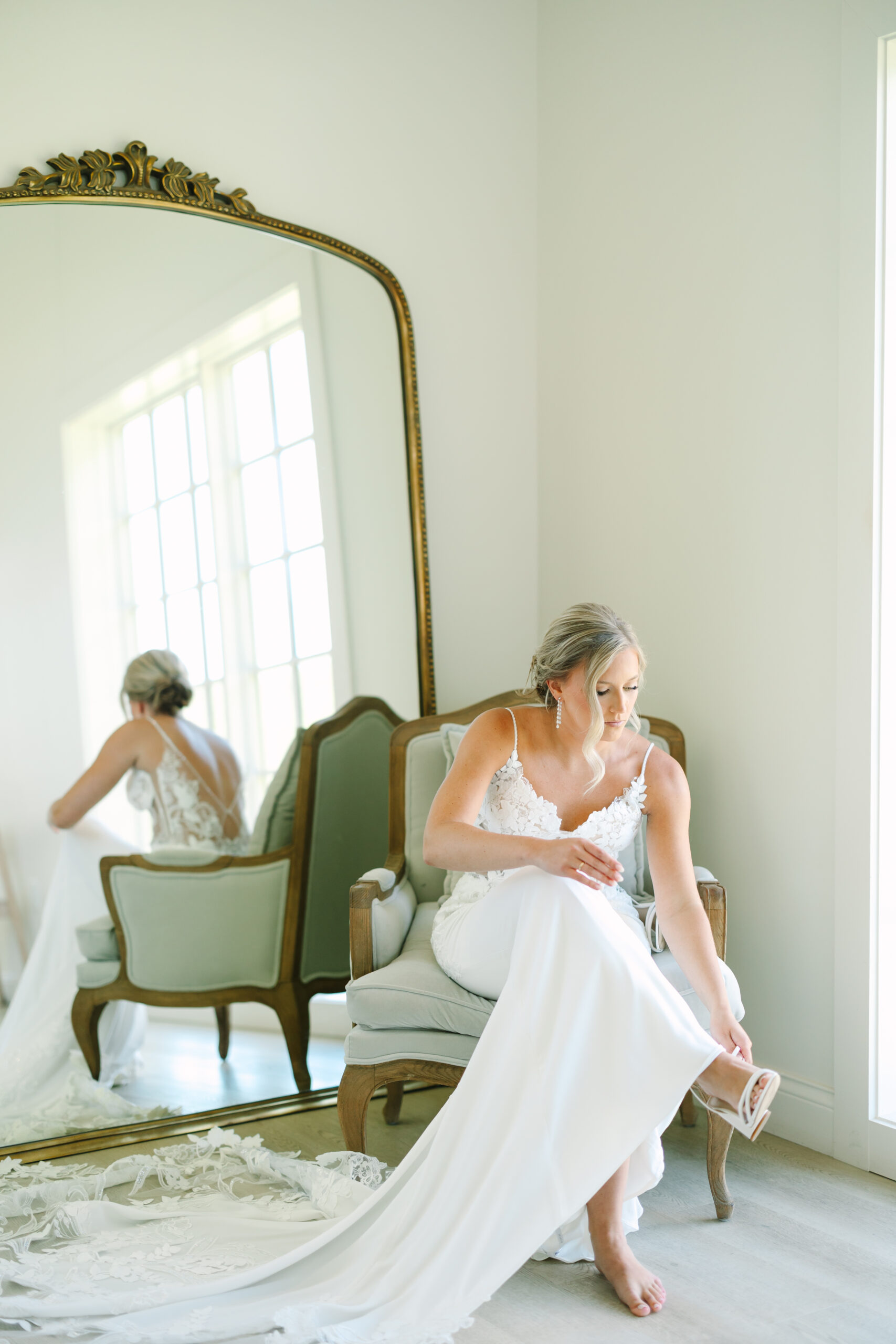 St. Louis wedding photographer captures bride putting on her shoes in the bridal suite at Westwind Hills